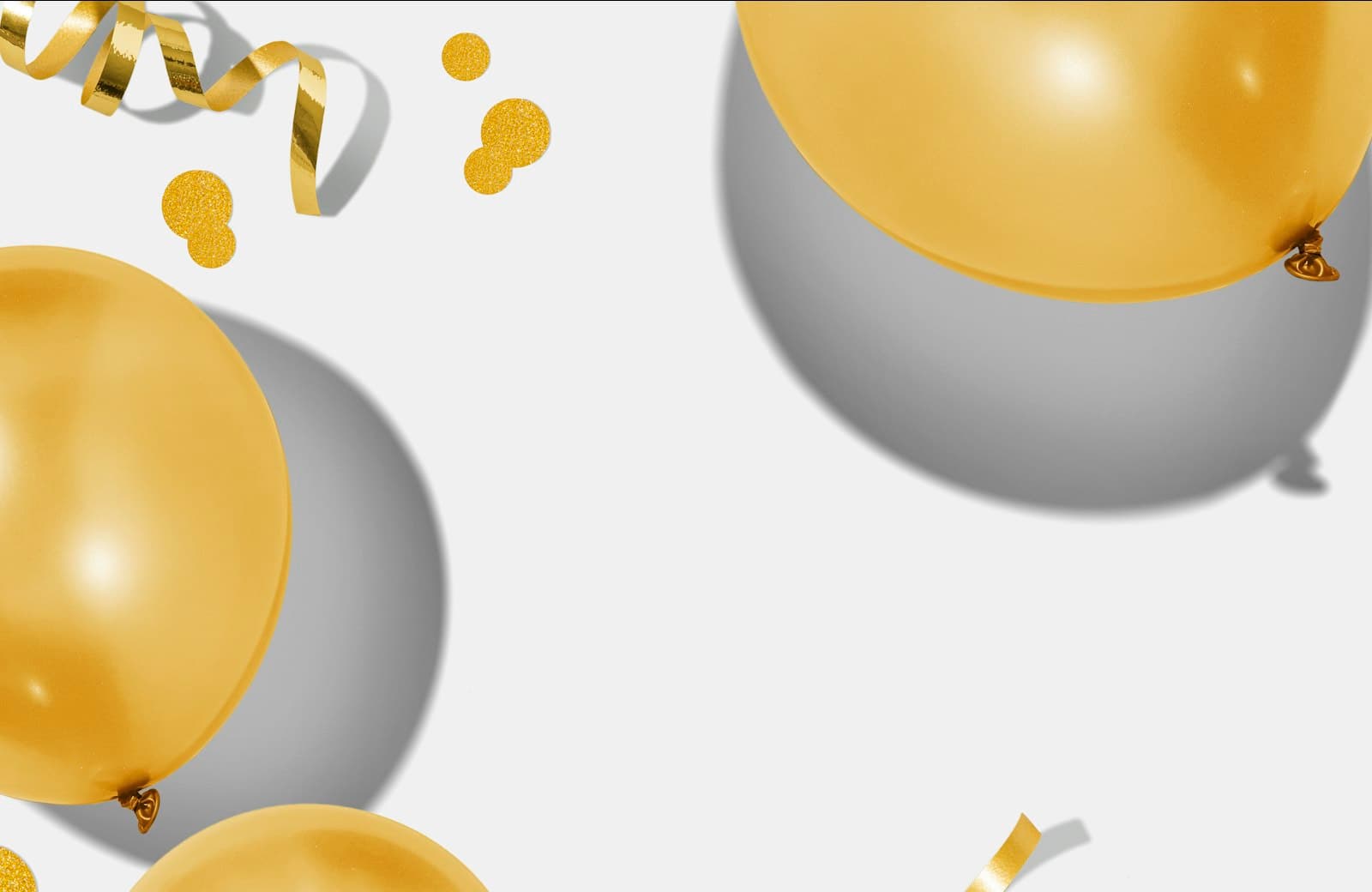 Gouden ballonnen met serpentine en confetti tegen een lichte achtergrond, een feestelijk beeld bij koekjes bestellen voor Abraham of Sarah