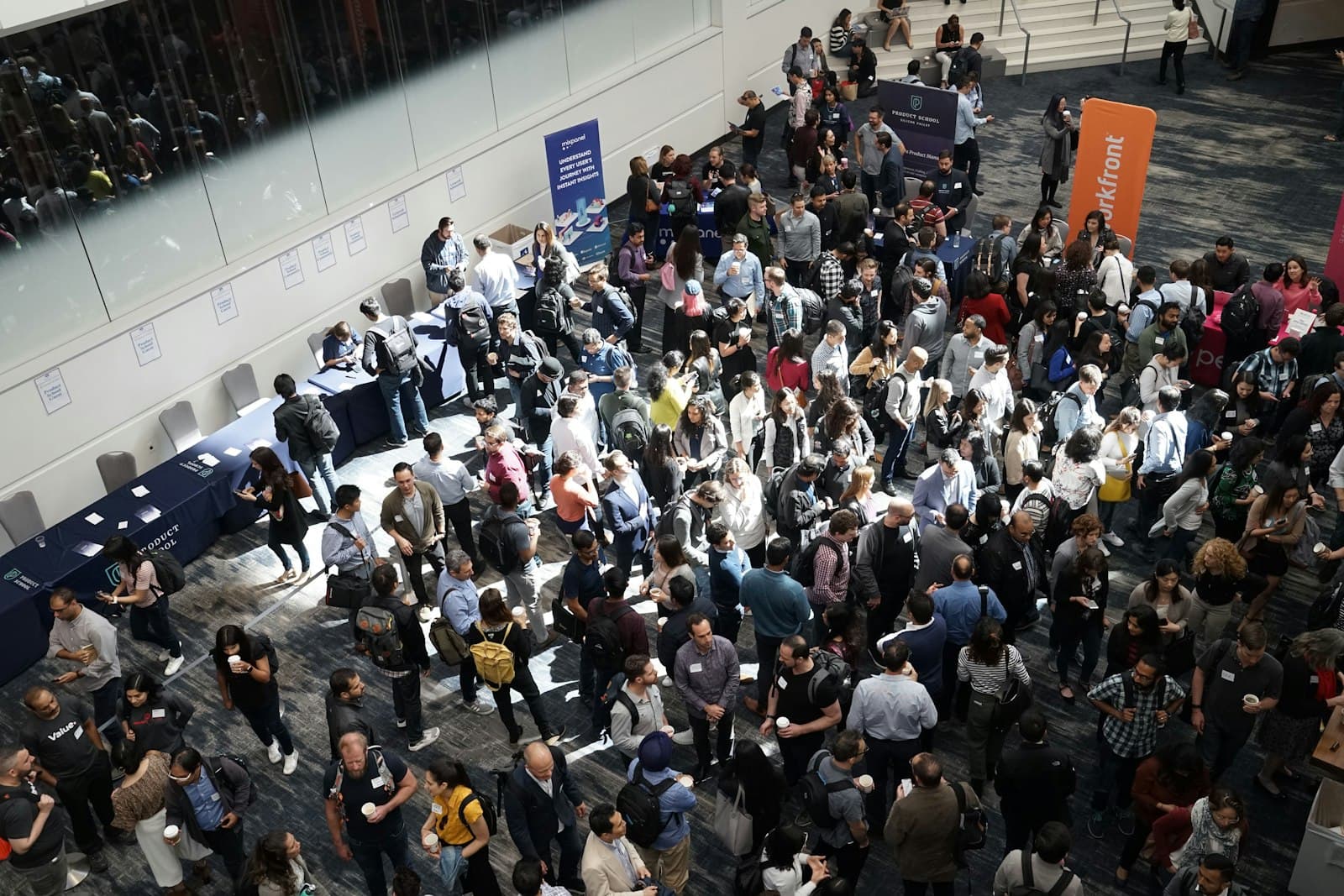 Een drukke beurshal vol bezoekers die langs de stands lopen tijdens een zakelijk evenement, een beeld bij koekjes bestellen voor een beurs