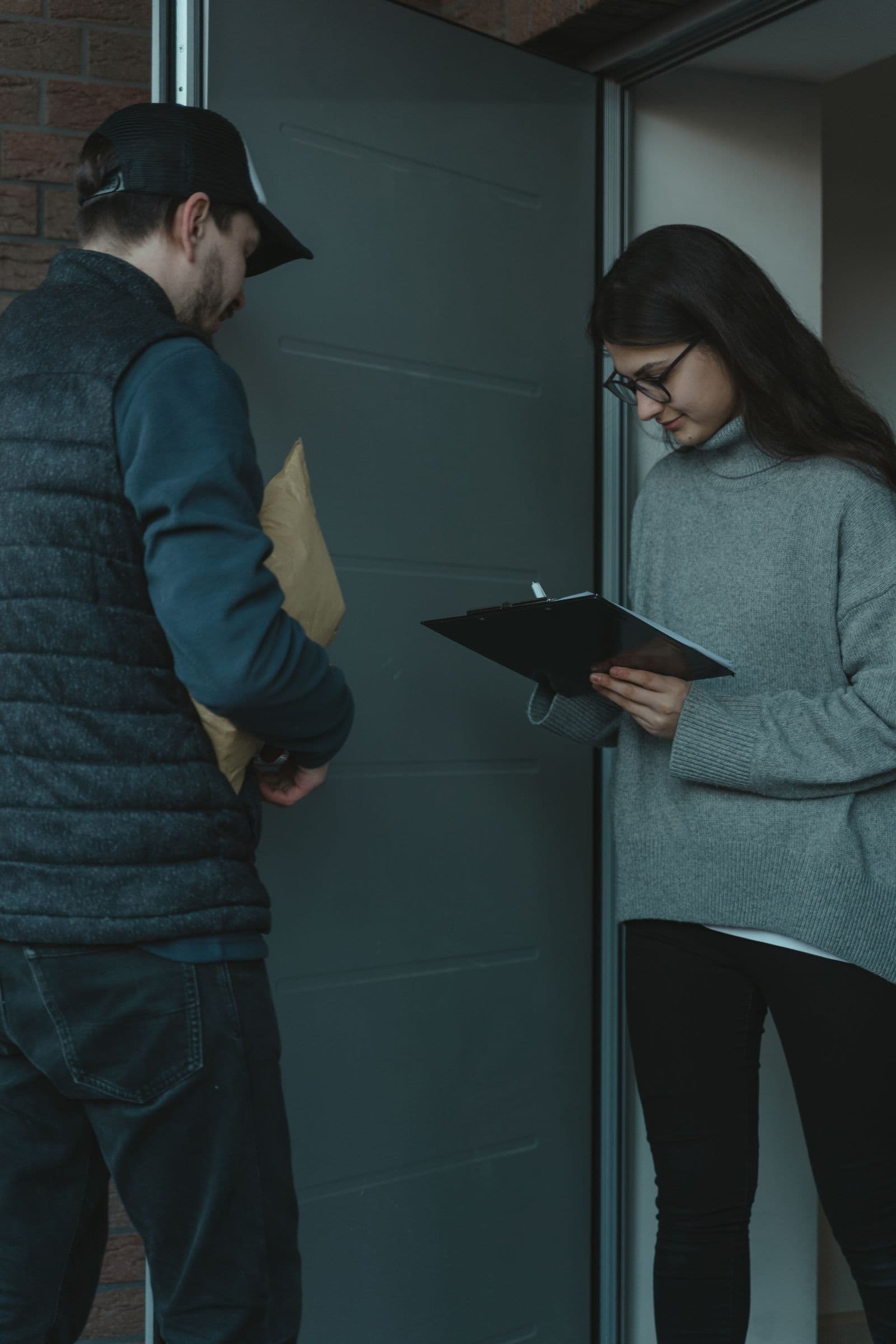 Iemand neemt aan de voordeur een pakketje in ontvangst van een bezorger, het moment waarop een onverwachte verrassing aankomt