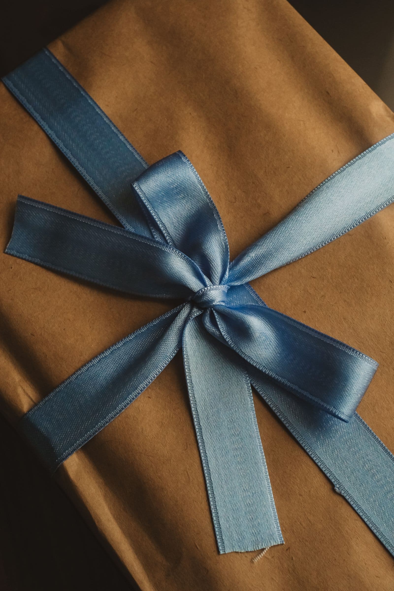Een cadeau in kraftpapier met een zacht lint eromheen, een beeld bij koekjes die als sorry worden verstuurd