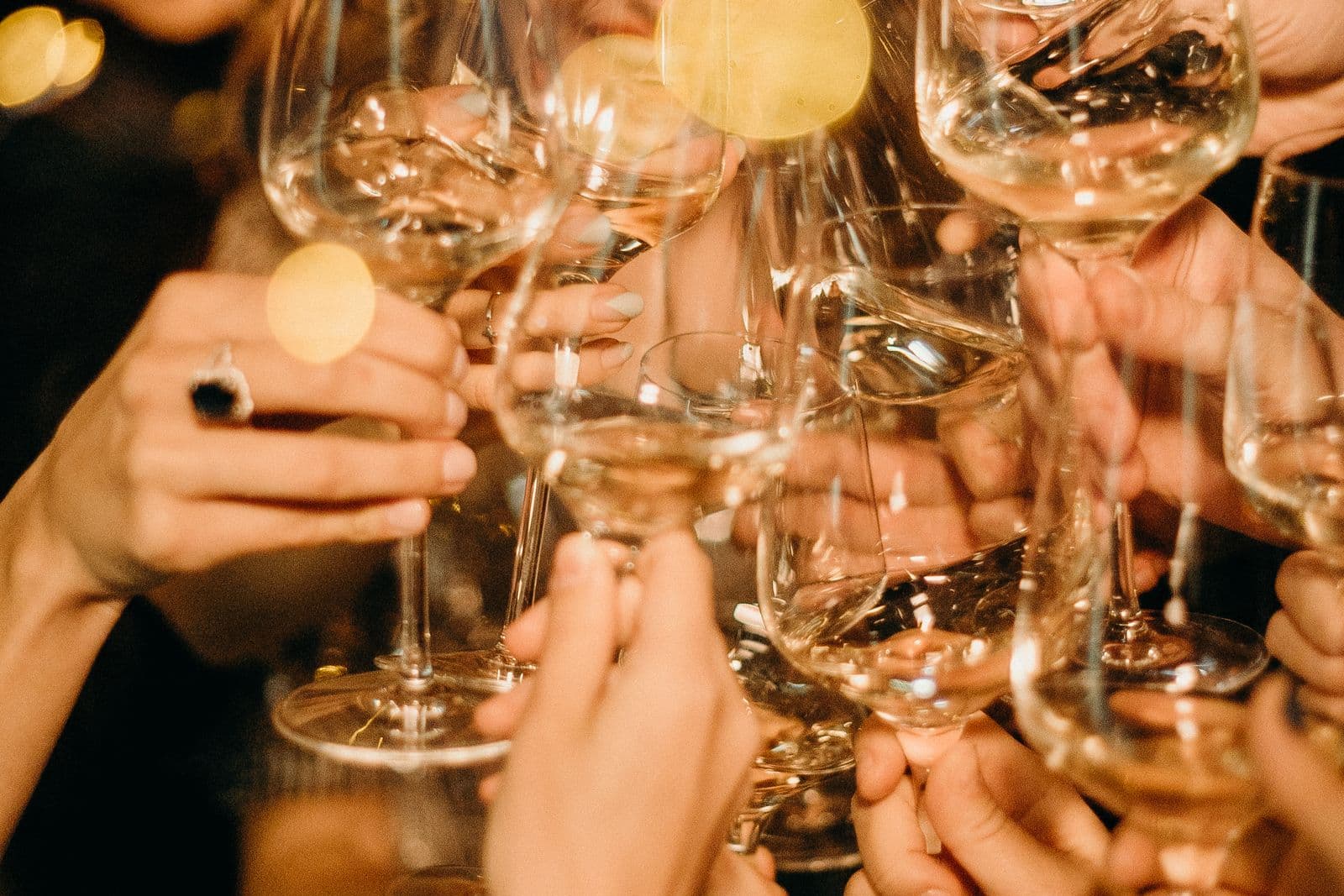 Vrienden proosten met glazen wijn in warm avondlicht om een verloving te vieren, een feestelijk beeld bij koekjes bestellen voor een verloving